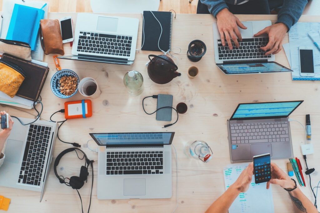 A desk with lots of laptops, showing life before implementing the digital minimalism philosophy
